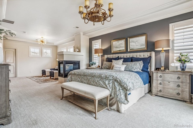 carpeted bedroom with a tile fireplace, an inviting chandelier, and ornamental molding