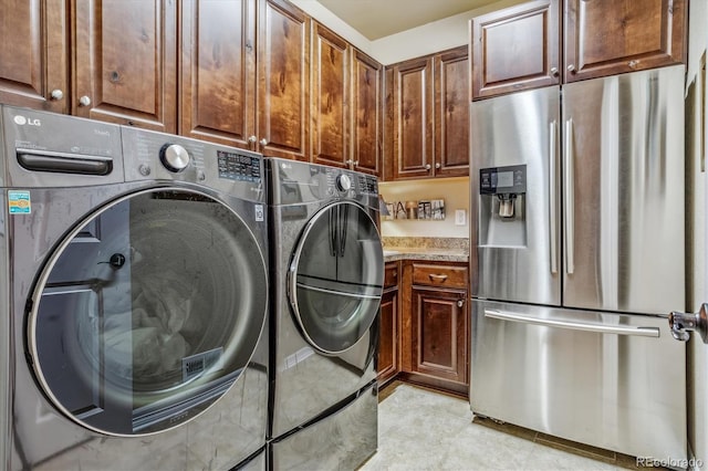 laundry area with washing machine and dryer and cabinets