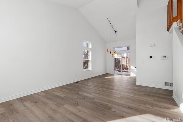 unfurnished living room featuring hardwood / wood-style flooring and high vaulted ceiling