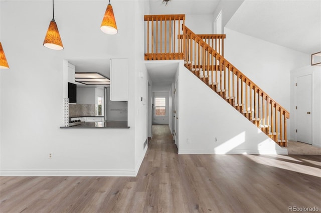 interior space with a high ceiling and light hardwood / wood-style flooring