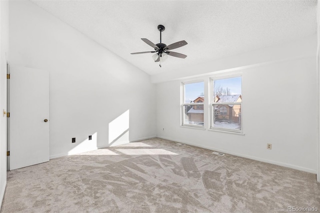 empty room featuring a textured ceiling, light colored carpet, ceiling fan, and lofted ceiling