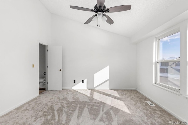 unfurnished room featuring a textured ceiling, light carpet, ceiling fan, and lofted ceiling