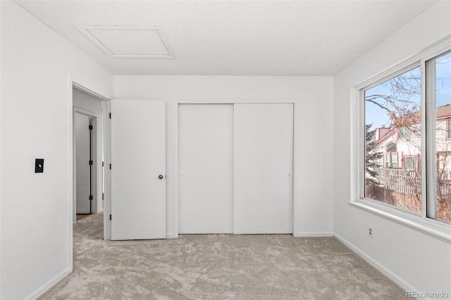 unfurnished bedroom featuring a closet, light colored carpet, and a textured ceiling