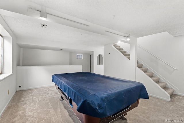 carpeted bedroom with a textured ceiling and pool table