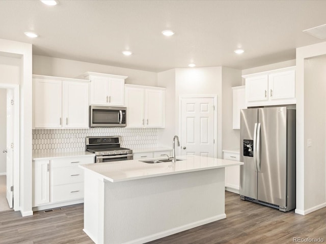 kitchen featuring stainless steel appliances, a kitchen island with sink, white cabinetry, and sink