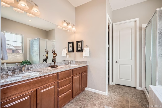 bathroom with double vanity, a stall shower, and a sink