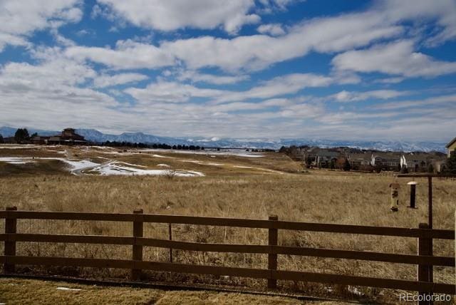 view of yard featuring fence, a mountain view, and a rural view