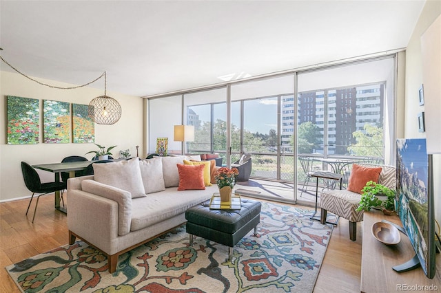 living room featuring a wall of windows and light hardwood / wood-style floors