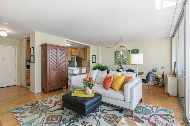 living room featuring light hardwood / wood-style flooring and a notable chandelier