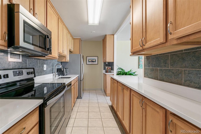 kitchen with tasteful backsplash, light tile patterned floors, sink, and appliances with stainless steel finishes