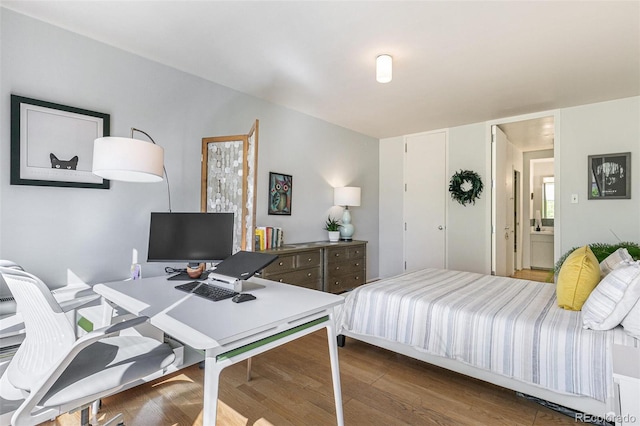 bedroom featuring ensuite bath and dark hardwood / wood-style floors