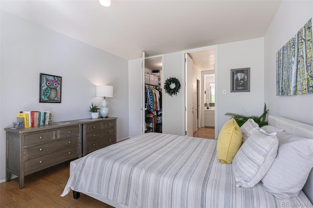 bedroom featuring connected bathroom, hardwood / wood-style floors, a closet, and a spacious closet