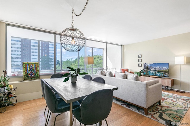 dining area with a chandelier and light hardwood / wood-style flooring