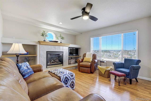 1944 Queens Canyon Ct, Colorado Springs, CO 80921 - living area with baseboards, a ceiling fan, wood finished floors, and a fireplace