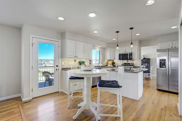 1944 Queens Canyon Ct, Colorado Springs, CO 80921 - kitchen featuring white cabinetry, recessed lighting, stainless steel appliances, backsplash, and pendant lighting