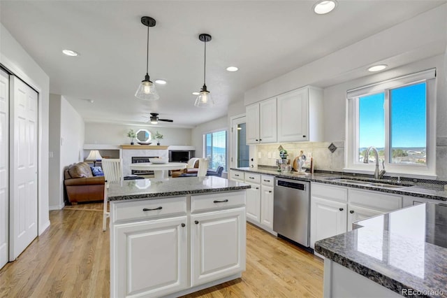 1944 Queens Canyon Ct, Colorado Springs, CO 80921 - kitchen featuring dark stone countertops, stainless steel dishwasher, a sink, and white cabinetry