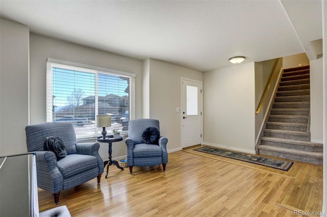 1944 Queens Canyon Ct, Colorado Springs, CO 80921 - living area with a textured ceiling, baseboards, light wood finished floors, and stairs