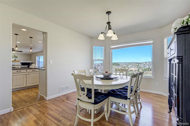 1944 Queens Canyon Ct, Colorado Springs, CO 80921 - dining area featuring baseboards, light wood finished floors, a notable chandelier, and visible vents