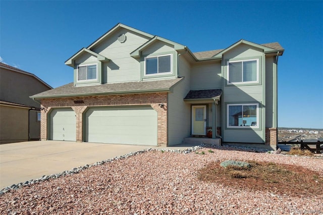 1944 Queens Canyon Ct, Colorado Springs, CO 80921 - view of front facade featuring an attached garage, a shingled roof, driveway, and brick siding