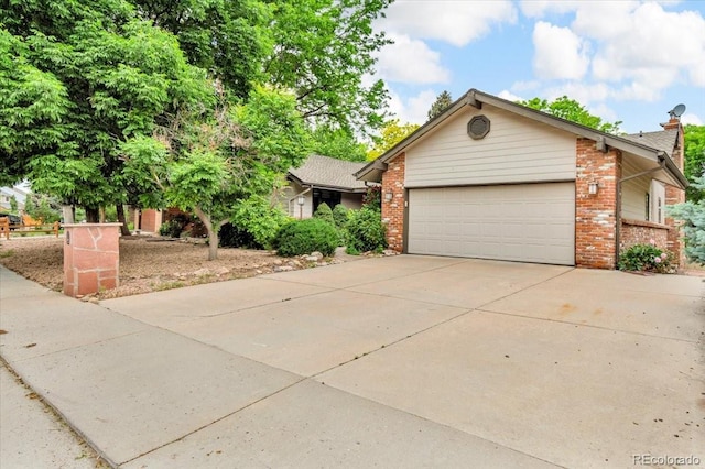 1665 W 113th Ave, Denver, CO 80234 - view of front of property featuring brick siding, driveway, an attached garage, and a chimney
