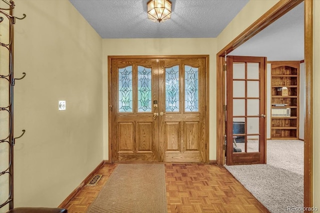 1665 W 113th Ave, Denver, CO 80234 - entryway with french doors, baseboards, and a textured ceiling