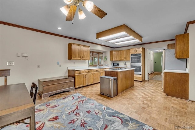 1665 W 113th Ave, Denver, CO 80234 - kitchen featuring appliances with stainless steel finishes, ornamental molding, a kitchen island, light countertops, and ceiling fan