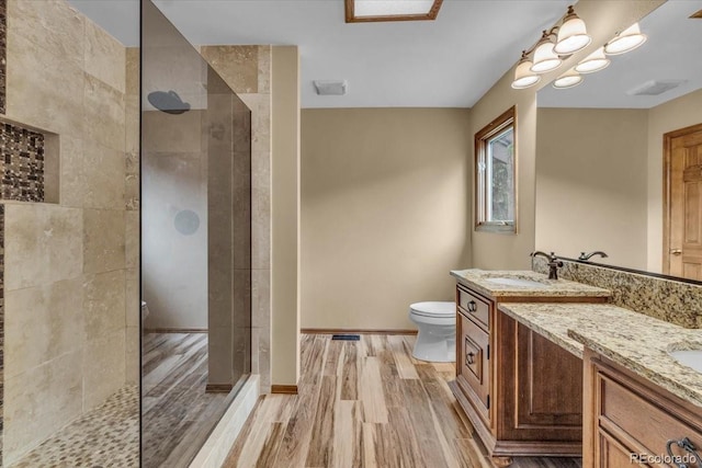 1665 W 113th Ave, Denver, CO 80234 - full bathroom with wood finished floors, toilet, a walk in shower, and vanity