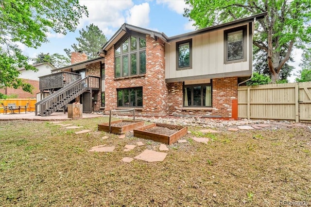 1665 W 113th Ave, Denver, CO 80234 - rear view of house with a garden, brick siding, a wooden deck, stairway, and a patio