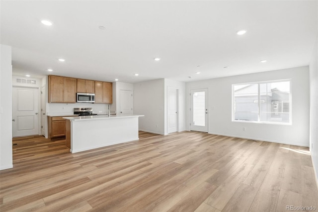 kitchen featuring stainless steel appliances, light wood finished floors, and recessed lighting