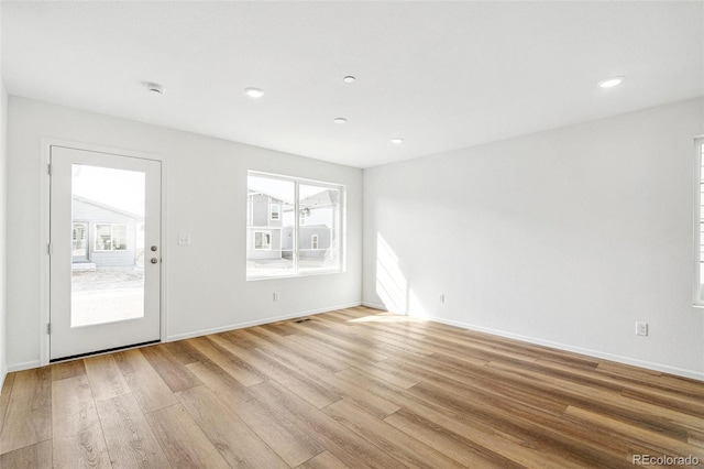 unfurnished room featuring recessed lighting, baseboards, and light wood finished floors