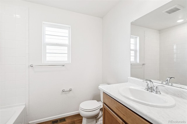 bathroom with wood finished floors, vanity, visible vents, and baseboards