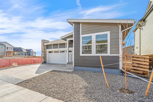 view of front facade with concrete driveway, fence, and an attached garage