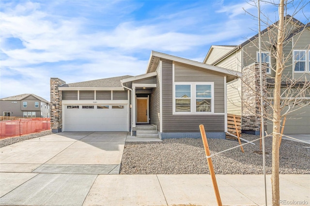 view of front of house featuring driveway, an attached garage, and fence