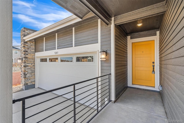 doorway to property featuring a garage and stone siding