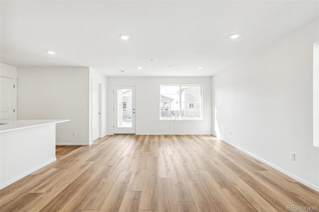 unfurnished living room featuring baseboards, light wood-type flooring, and recessed lighting