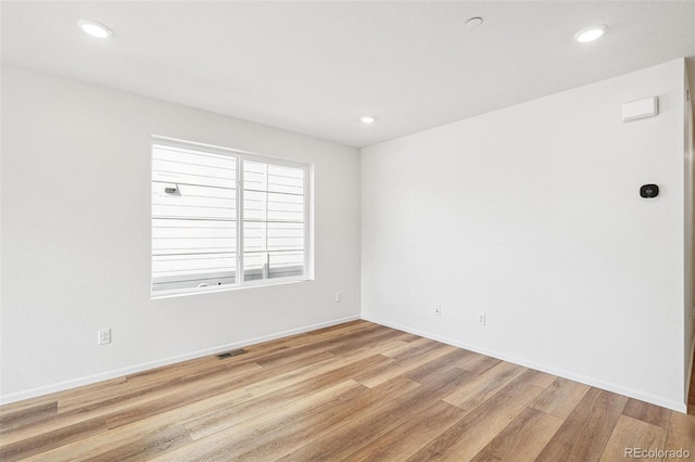 empty room featuring visible vents, baseboards, light wood-style flooring, and recessed lighting