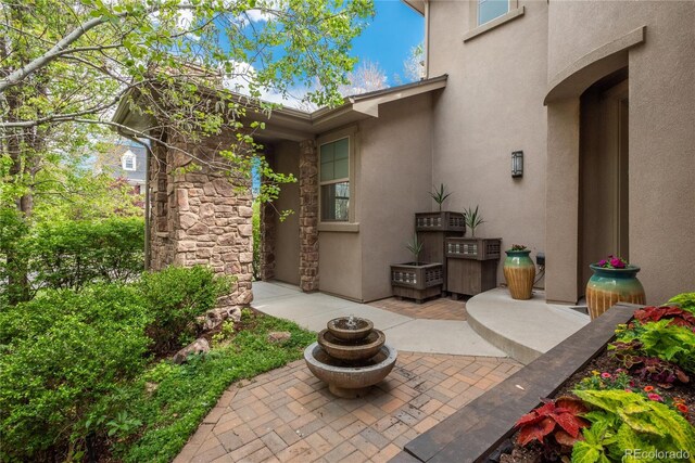 9266 E 35th Ave, Denver, CO 80238 - property entrance featuring stucco siding, a patio area, and stone siding