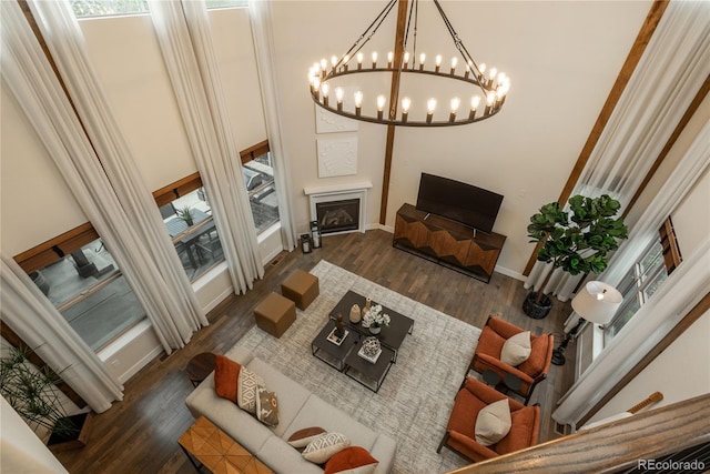 9266 E 35th Ave, Denver, CO 80238 - living area featuring wood finished floors, baseboards, a chandelier, a towering ceiling, and a fireplace