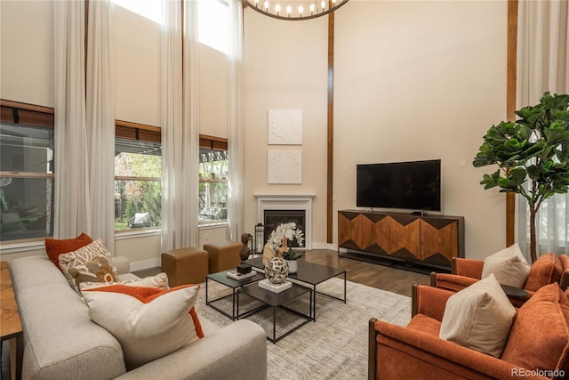 9266 E 35th Ave, Denver, CO 80238 - living room with wood finished floors, a high ceiling, a fireplace, a chandelier, and baseboards