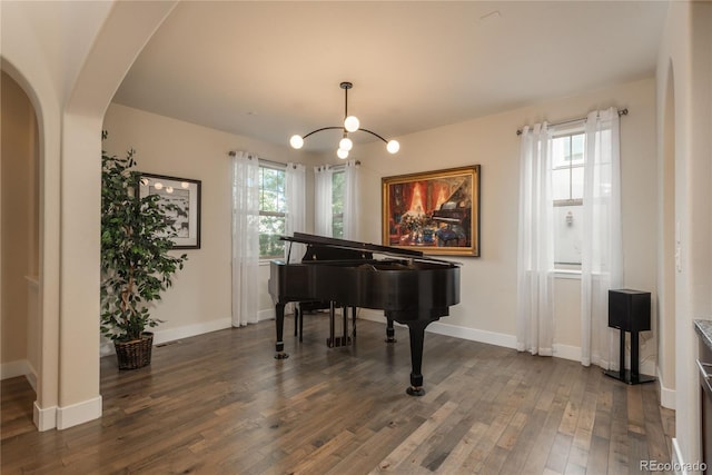 9266 E 35th Ave, Denver, CO 80238 - sitting room featuring a chandelier, dark wood finished floors, arched walkways, and baseboards