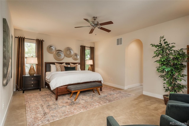 9266 E 35th Ave, Denver, CO 80238 - bedroom featuring arched walkways, multiple windows, light colored carpet, and baseboards