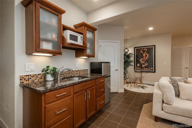 9266 E 35th Ave, Denver, CO 80238 - kitchen featuring white microwave, freestanding refrigerator, a sink, dark stone countertops, and dark tile patterned flooring