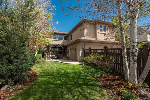 9266 E 35th Ave, Denver, CO 80238 - back of property featuring a patio, stucco siding, and an attached garage