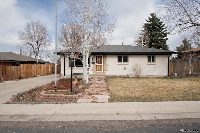 view of front of property featuring brick siding, a shingled roof, a front lawn, and fence