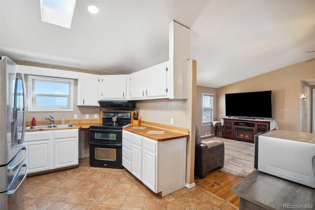 6670 Indian Village Hts, Fountain, CO 80817 - kitchen with range with two ovens, freestanding refrigerator, vaulted ceiling, open floor plan, and extractor fan