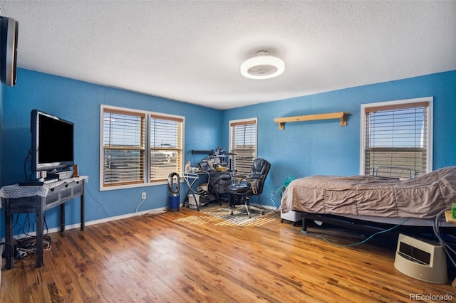 6670 Indian Village Hts, Fountain, CO 80817 - bedroom featuring a textured ceiling, wood finished floors, baseboards, and a textured wall