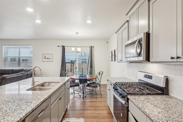 715 N Amory St, Watkins, CO 80137 - kitchen featuring appliances with stainless steel finishes, a sink, a chandelier, plenty of natural light, and recessed lighting