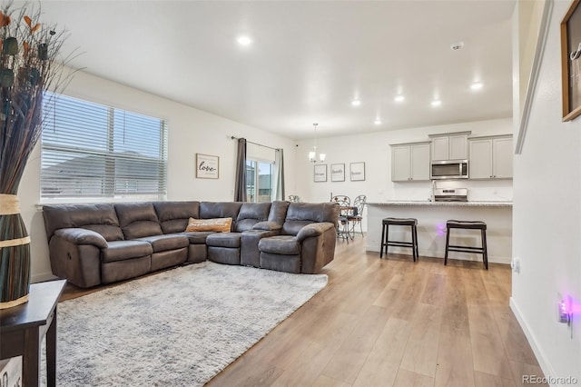 715 N Amory St, Watkins, CO 80137 - living area featuring light wood-type flooring, a chandelier, recessed lighting, and baseboards