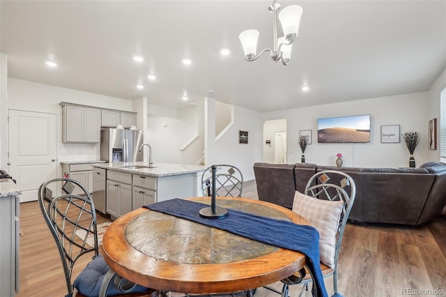 715 N Amory St, Watkins, CO 80137 - dining space featuring light wood finished floors, stairs, a chandelier, and recessed lighting