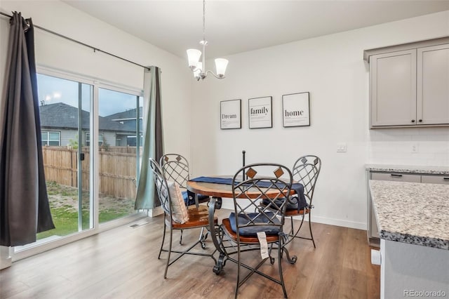 715 N Amory St, Watkins, CO 80137 - dining room with wood finished floors, a chandelier, and baseboards